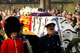 Soldiers accompany a gun carriage holding the coffin bearing the Queen Mother April 5, 2002.