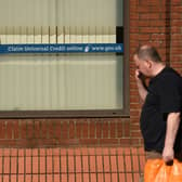 A man walks past a sign with the email address of ‘universal credit’ outside a Job Centre.