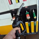 A man poses holding a petrol pump nozzle at a filling station in Birkenhead, north-west England.  (Photo credit should read PAUL ELLIS/AFP via Getty Images)