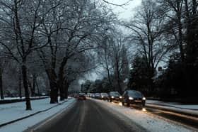 Cars drive on snowy roads.