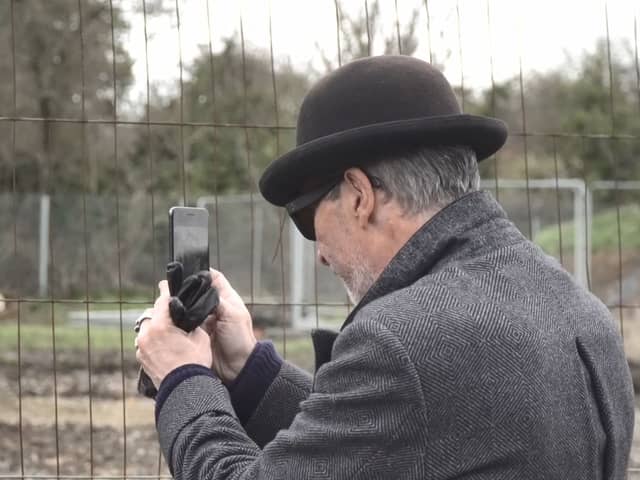 A mystery man in a bowler hat has been seen scoping out a famous site where the illusive artist Banksy left a mural that was inadvertently torn down by builders