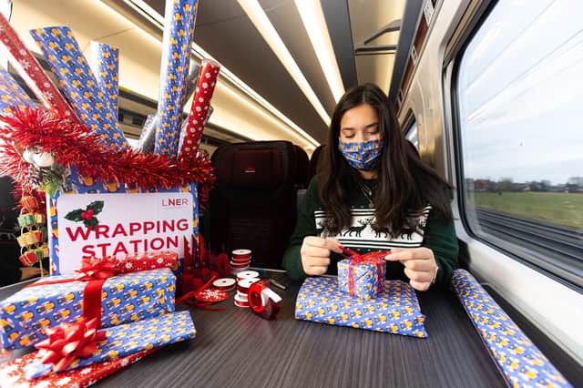 Professional gift wrapper Finn Drumgoole wraps presents for LNER customers to launch the rail operators complimentary Rail Wrapping service (photo: David Parry/PA Wire)
