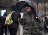 Woman walks in stormy conditions.