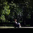 A woman reads a book on a bench in Green Park in central London on September 5, 2023 as the country experiences a late heatwave.