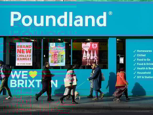 Shoppers walk past a Poundland shop in Brixton, south London.
