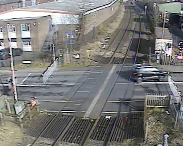 A car ignoring the signals and crossing the other side of the road to quickly dodge the closing barriers (Langley Green level crossing, West Midlands).  