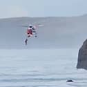 Footage capturing a dog walker being airlifted to safety after falling from a coastal path in Cornwall.  