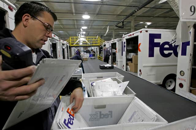 A FedEx courier sorts packages before starting his delivery route (Photo: Justin Sullivan/Getty Images)
