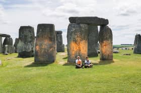 Activists sitting by Stonehenge after it was sprayed orange (Photo: Just Stop Oil / Supplied)