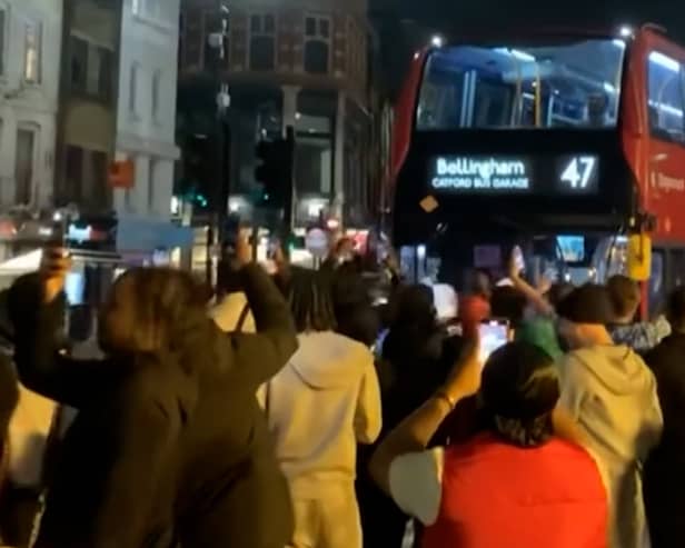 Excited England fans dance around “Bellingham” bus.