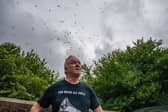 Gary Hough, 62, looks up to the skies outside his home surrounded in seagull
