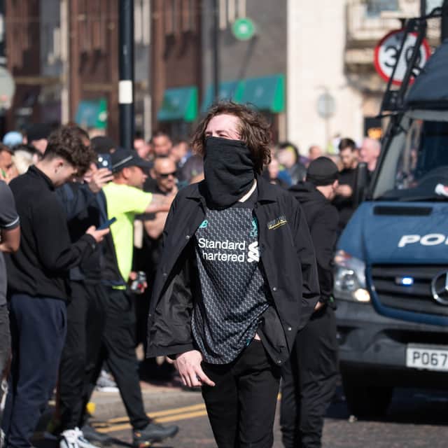a protestor walks past a police van near Blackpool Town Hall