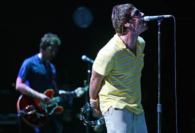Liam (R) and Noel Gallagher perform on stage. Photo: JOSE JORDAN/AFP via Getty Images