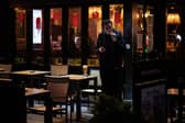 Man smokes a cigarette outside pub.