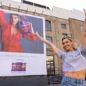 Ashley puts sweat shame to sweat fame by standing in front of her sweating billboard as the new face of Extra Flamin' Hot snacks