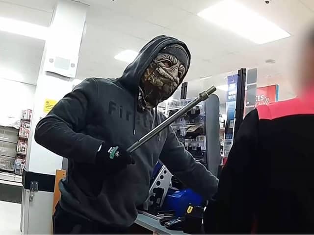 Moment armed robber in Halloween mask raids shop till.