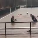Lydney Town AFC players go swimming on their pitch.