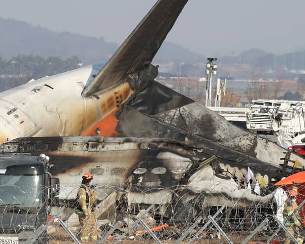 Firefighters check near the wreckage of a passenger plane at Muan International Airport 