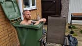 Martin Lynch taking a cold water bath in his wheelie bin