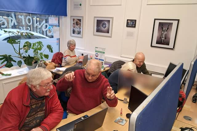 Volunteers help users with their phones and laptops