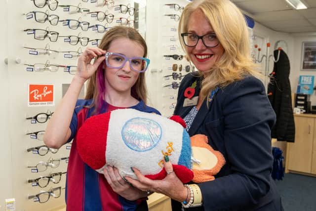 Scrivens Out of this World 'Design a Spec' colouring competition winner Scarlett Devlin (age 10) being presented with her prize by Chapel en le Frith branch manager Helen Bamforth