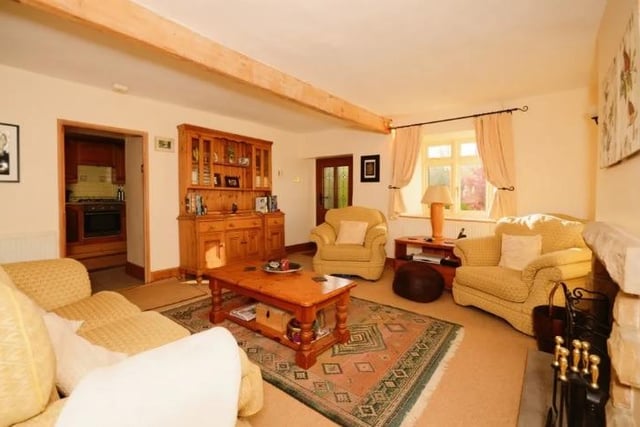 A log burning multi-fuel stove housed in a stone hearth and exposed ceiling beams are eye-catching features of this charming room. The window, which has a deep sill, looks out over the front garden.