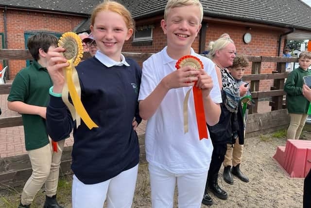 Elsa Booth and Jacob Taylor proudly show off their rosettes at the RDA Regional Countryside Challenge Qualifier.