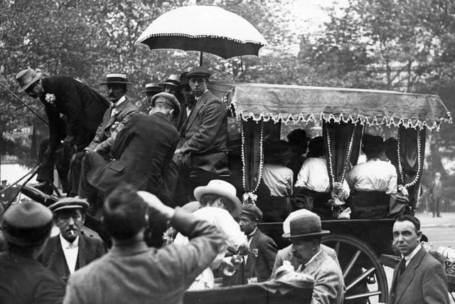 A coach on the Derby road with parasol and curtains overtakes an open cart in around 1910.