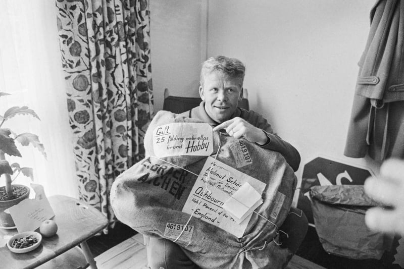 West German footballer Helmut Haller with a delivery of 25 folding umbrellas which have been sent to the team at their Derbyshire hotel to help them cope with British weather on 14th July 1966.