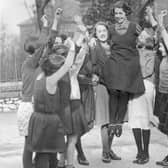 Four year0old Buxton schoolgirl Peggy Mycock is cheered by her friends for being chosen as the 1934 Festival Queen of Buxton, Derbyshire. She was selected out of 30 girls from local elementary schools.