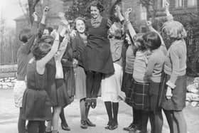 Four year0old Buxton schoolgirl Peggy Mycock is cheered by her friends for being chosen as the 1934 Festival Queen of Buxton, Derbyshire. She was selected out of 30 girls from local elementary schools.