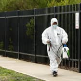 A cleaner in protective gear with specialist equipment. Picture: Darrian Traynor/Getty Images.