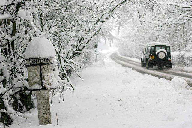 A car drives past a snow-covered mile-marker sign in Derbyshire on March 23, 2013. Heavy unseasonal snowfall hit, bringing sub-zero temperatures and travel disruption across the area.