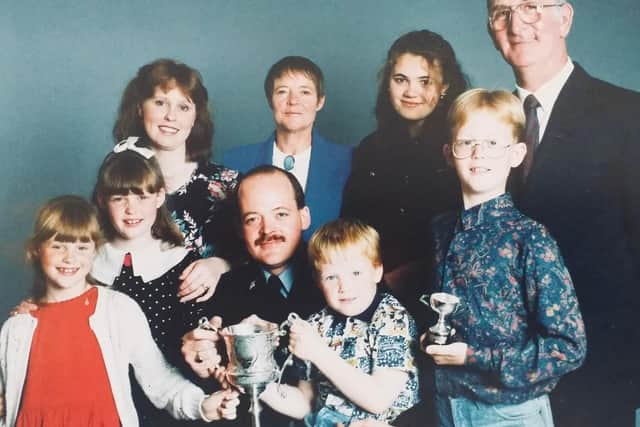 Andy and family with his Derbyshire Community Officer of the Year award. From left are daughters Rebecca and Beth, wife Jenny, mother Maureen, foster daughter Helen, son Joe, father Bernard and son Thomas, seated.