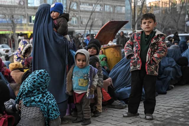 Children wait for free bread in front of a bakery in Kabul on January 24, 2022. (Photo by Mohd RASFAN / AFP) (Photo by MOHD RASFAN/AFP via Getty Images)