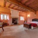 The focal point of the room is the open fireplace with a stone mantel, brick surround, stone hearth and an original over mantel with trailing leaves and grotesque mask.