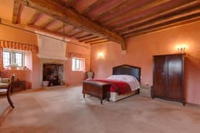 The focal point of the room is the open fireplace with a stone mantel, brick surround, stone hearth and an original over mantel with trailing leaves and grotesque mask.