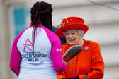 The Queen passes her baton to the baton bearer, British parasport athlete Kadeena Cox, during the launch of the Queen's Baton Relay for Birmingham 2022. (Photo by Victoria Jones - WPA Pool/Getty Images)