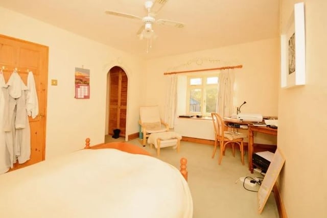 An archway in the main bedroom leads to a dressing room which has built-in storage cupboards.