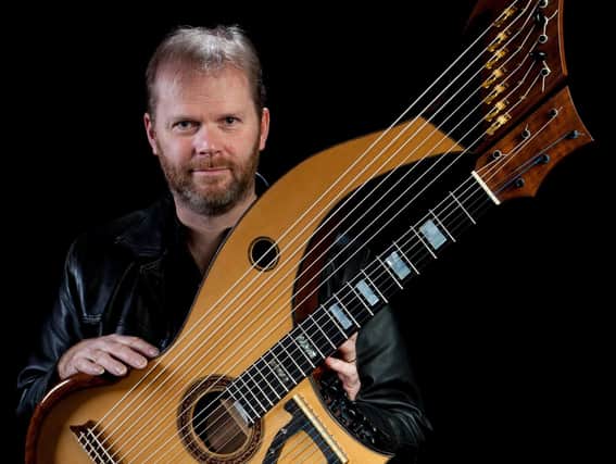 Jonathan Pickard with a harp-guitar which he has designed.