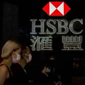 Pedestrians walking past the logo for HSBC in Hong Kong. (Photo by ISAAC LAWRENCE / AFP) (Photo by ISAAC LAWRENCE/AFP via Getty Images)