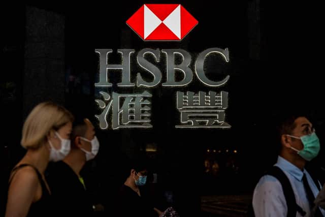Pedestrians walking past the logo for HSBC in Hong Kong. (Photo by ISAAC LAWRENCE / AFP) (Photo by ISAAC LAWRENCE/AFP via Getty Images)