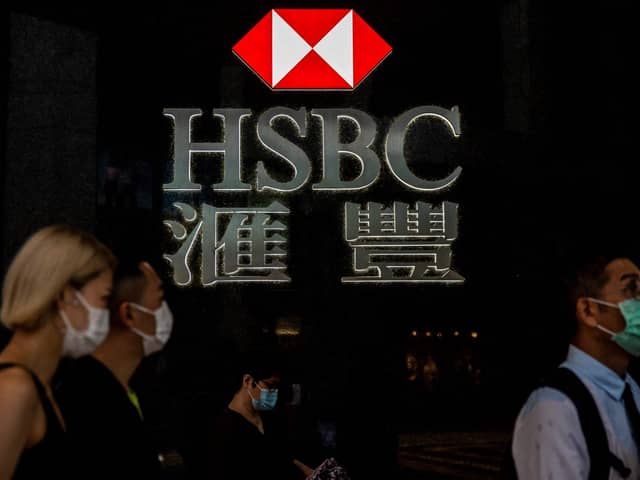 Pedestrians walking past the logo for HSBC in Hong Kong. (Photo by ISAAC LAWRENCE / AFP) (Photo by ISAAC LAWRENCE/AFP via Getty Images)