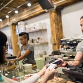 Customer paying barista with credit card in cafe