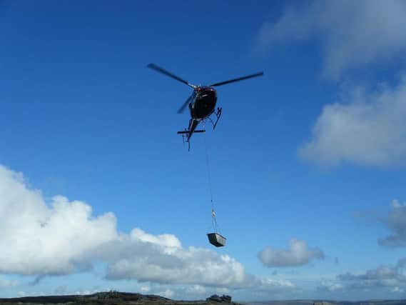 Helicopters transport the heavy materials onto the moors.