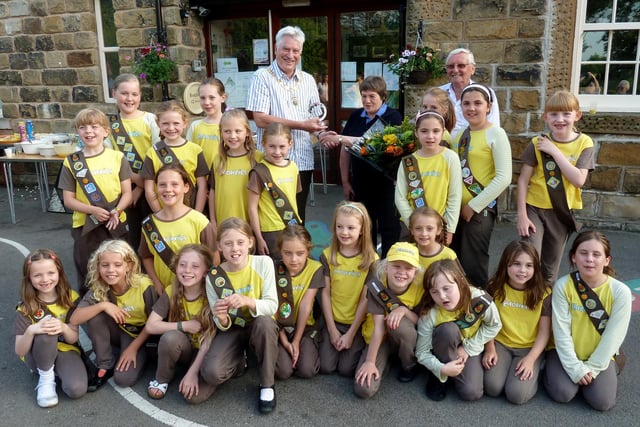 Leader of 1st Combs Brownies, Janet McNicol has been presented with a community award by Chapel Parish Council in recognition of her dedication to the brownies for nearly five decades. She is pictured receiving her award from Cllr Liam McCarthy, chair of the parish council, and Cllr Peter Harrison, along with her Brownies, in 2013.