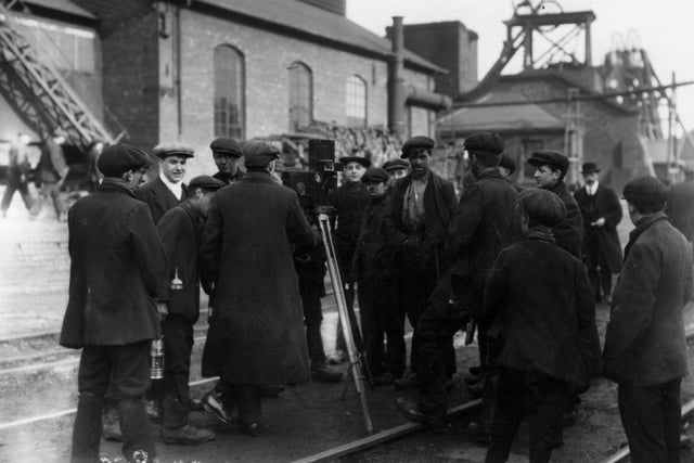 Miners in Derbyshire surround a cinematographer at work in 1912