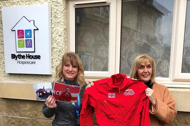 Caroline Morgan, community fundraiser of Blythe House and Helen’s Trust receiving the suit from Penny Skelton, (mother of Nick Critchell)