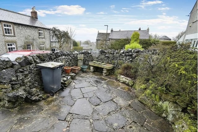 The rear courtyard has a stone boundary wall, stone flags and a variety of mature plants and shrubs. The oil tank is also located in this area.