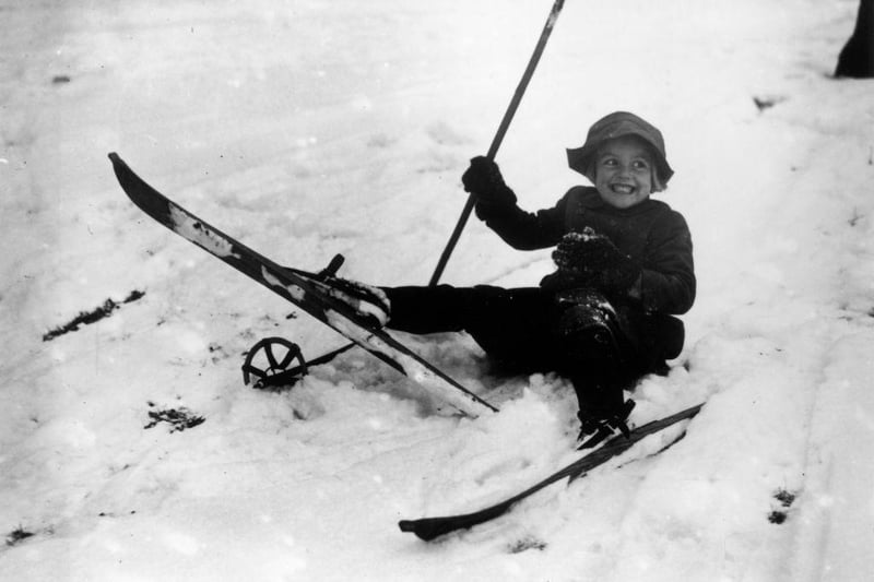 Young skier Tamsin Heardman is amused after falling over on her skies in Edale on 21st December 1938.